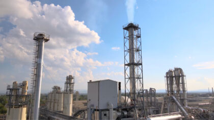 Industriële schoorstenen en installaties in een chemisch complex onder blauwe lucht