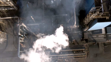 Luchtbeeld van industriële installatie met rookontwikkeling uit pijpleidingen