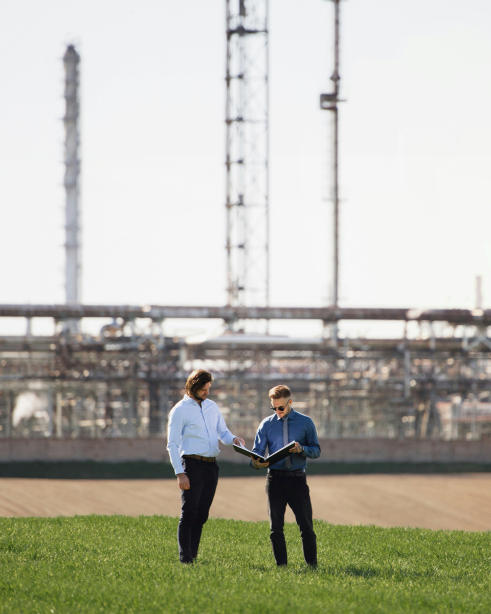 Twee adviseurs analyseren EED-auditresultaten op locatie bij een industriële installatie