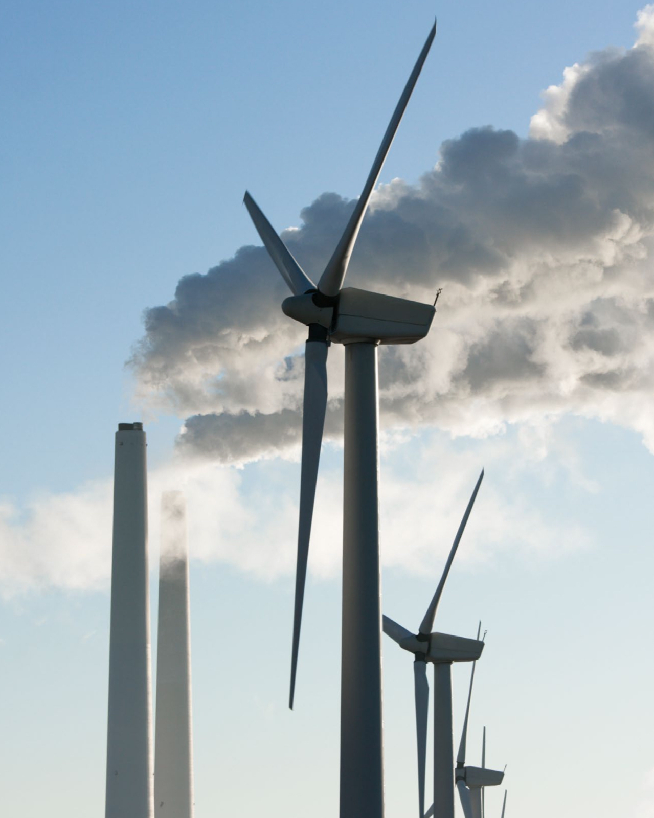 Schoorstenen van een industriële installatie met rookgasafvoer en windmolens