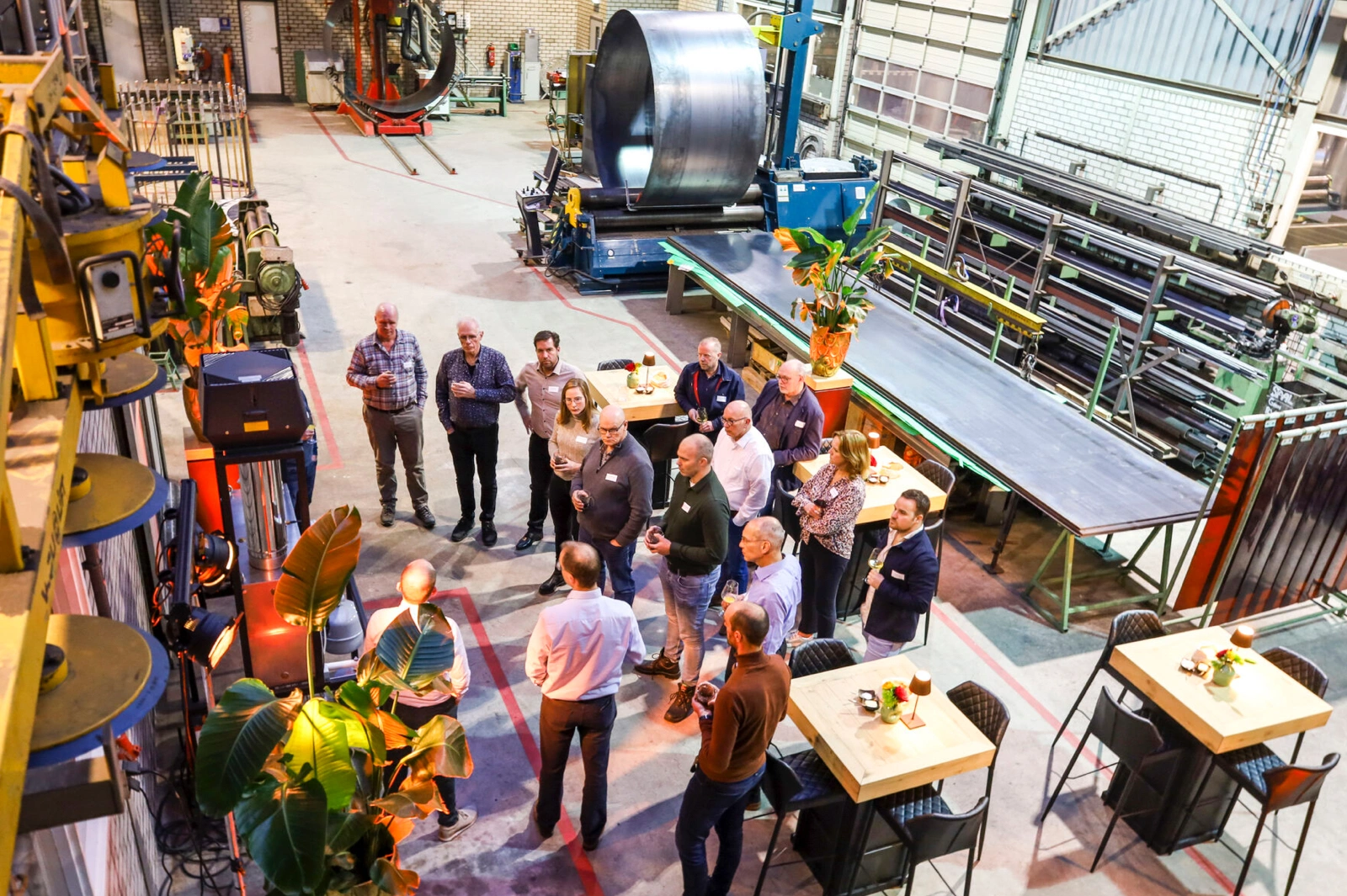 Groep deelnemers aan seminar over duurzaam bakken verzameld in een industriële werkplaatsomgeving.