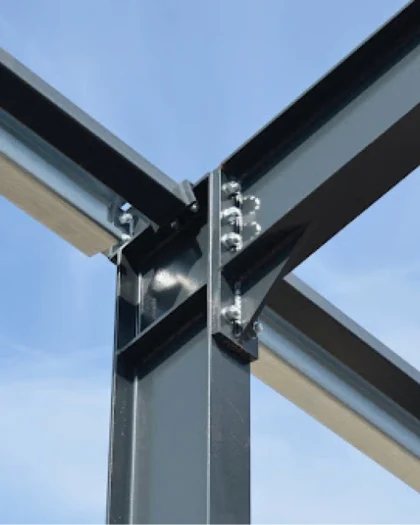 Detail van een stalen balkconstructie tegen een heldere blauwe lucht, symbool voor hoogwaardige staalbouw.