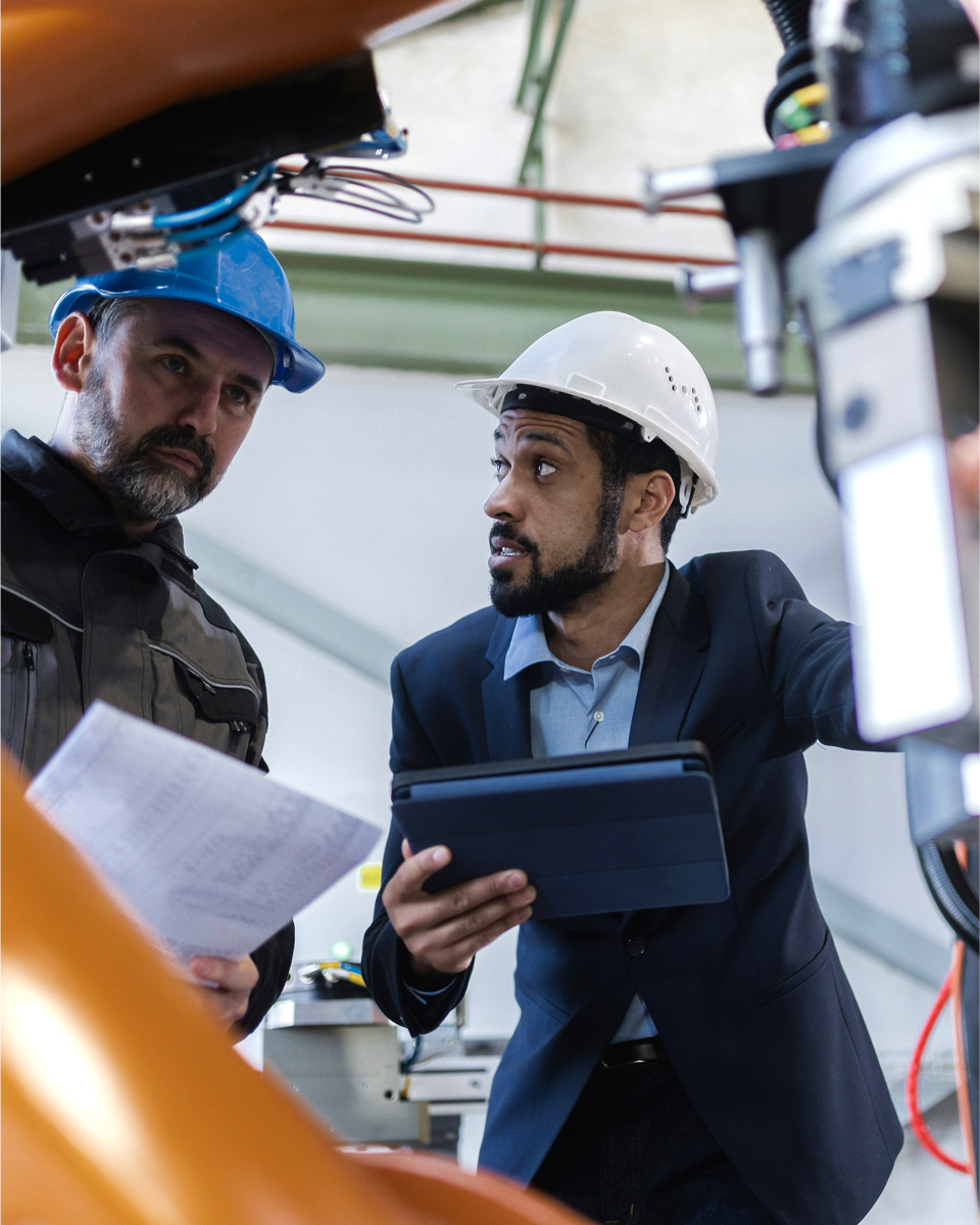 Twee technici bespreken warmteterugwinningsopties in een industriële omgeving