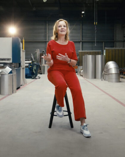 Martine Goedegebuure zit op een kruk in de assemblagehal van Heat Matrix tijdens de Dag van de Ondernemer.