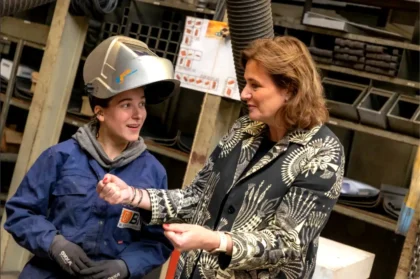 Minister Karien van Gennip in gesprek met een jonge technicus van Bos Nieuwerkerk tijdens werkbezoek aan de werkplaats.