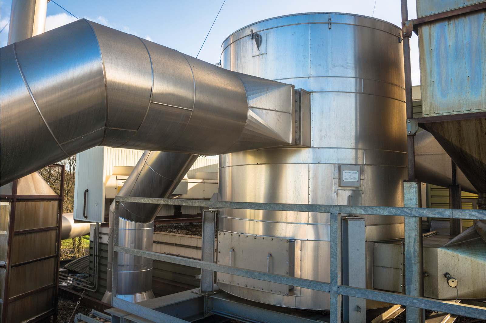 Industriële installatie met buizen en warmtewisselaar voor restwarmtebenutting