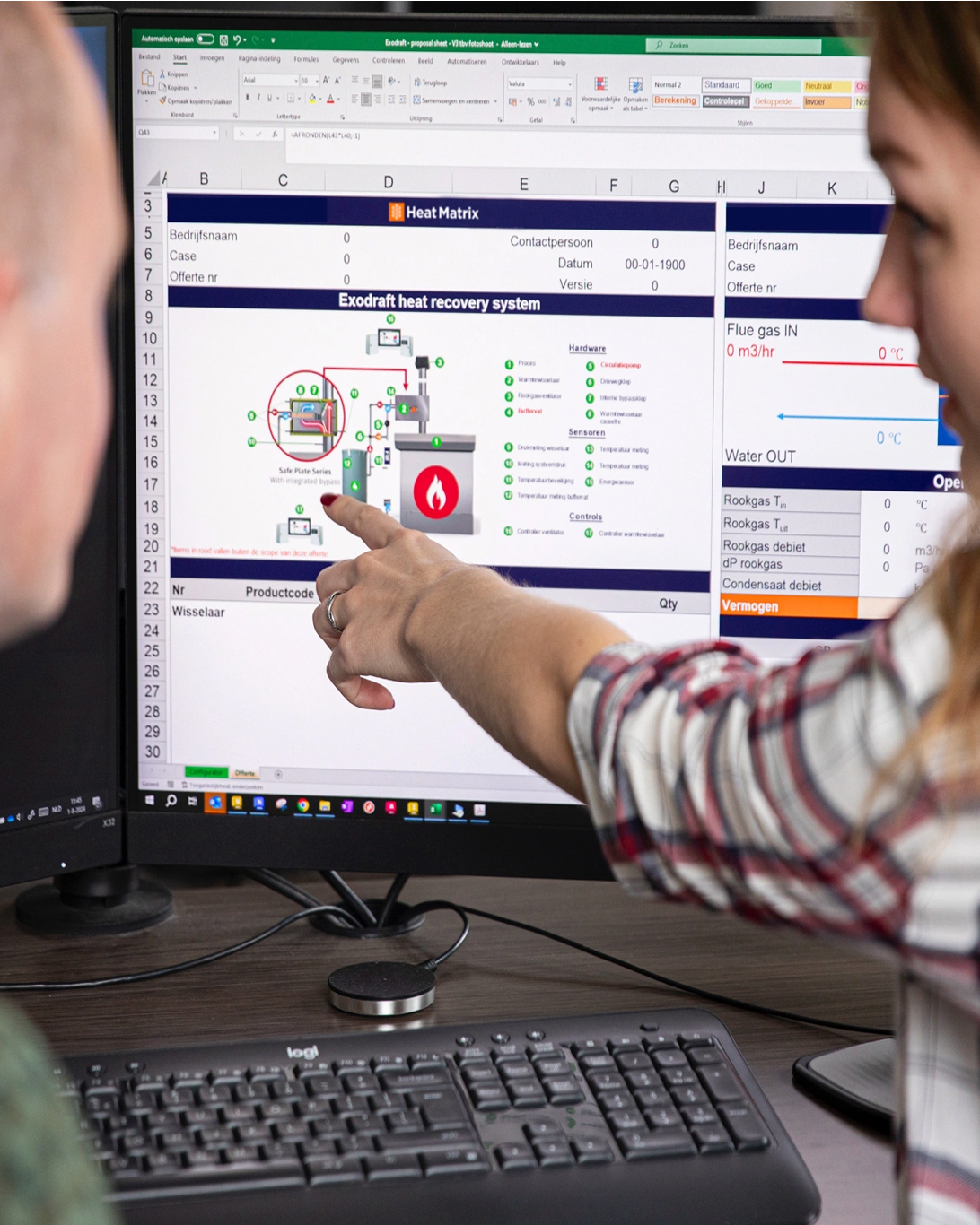 Twee medewerkers van Heat Matrix analyseren samen een warmteterugwinningssysteem op een computerscherm.