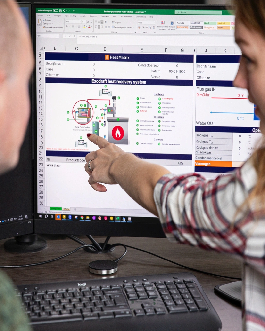 Twee medewerkers van Heat Matrix analyseren samen een warmteterugwinningssysteem op een computerscherm.